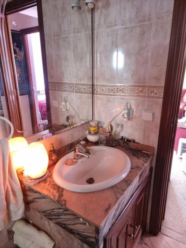 a bathroom with a sink and a mirror at Apto Templo de Isis, Habitación Verde en Amate in Seville