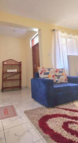 a blue couch in a living room with a crib at The Great Stay Mtwapa in Mtwapa