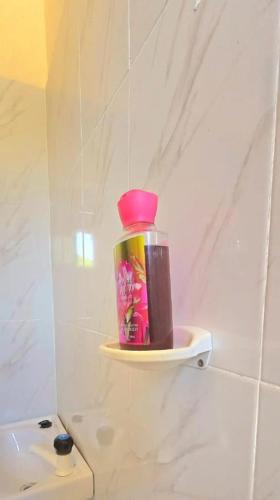 a bottle on a shelf above a toilet in a bathroom at The Great Stay Mtwapa in Mtwapa