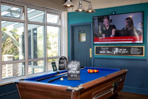 a room with a pool table and a flat screen tv at Commodore Hotel by Greene King Inns in Bournemouth