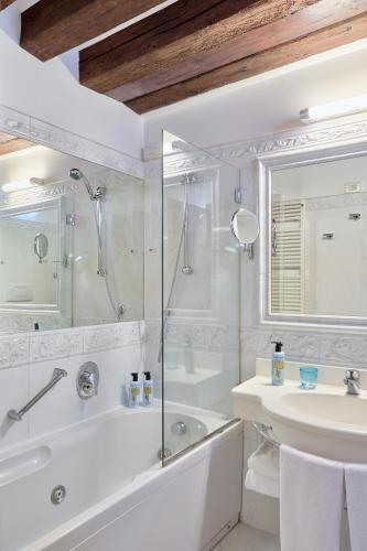 un bagno bianco con doccia e lavandino di Locanda Vivaldi a Venezia