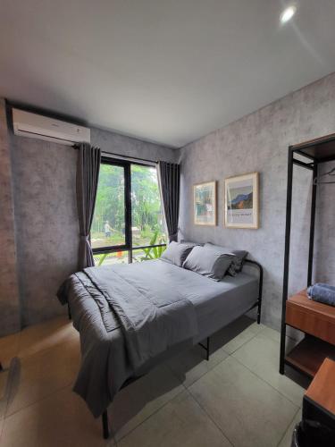 a bedroom with a bed and a window at Hebe Hotel, Hostel & Hospitality Network in Sawah