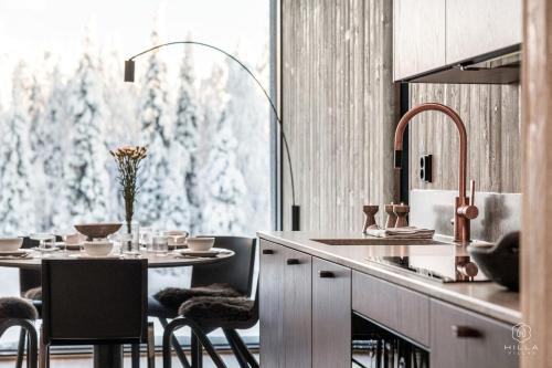 a kitchen with a table with chairs and a window at North Suite Eclipse 15A by Hilla Villas in Kittilä