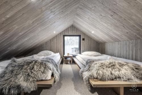 a attic bedroom with two beds with furry pillows at North Suite Eclipse 15A by Hilla Villas in Kittilä