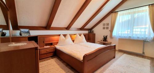 a bedroom with a bed and a desk and a window at Haus an der Mur in Mureck