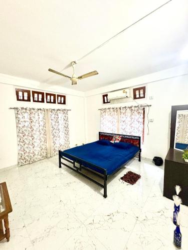 a bedroom with a blue bed in a room at Puspalay Homestay in Guwahati