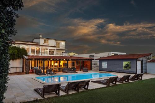 a house with a swimming pool in the yard at FreeSurfCamp in Peniche