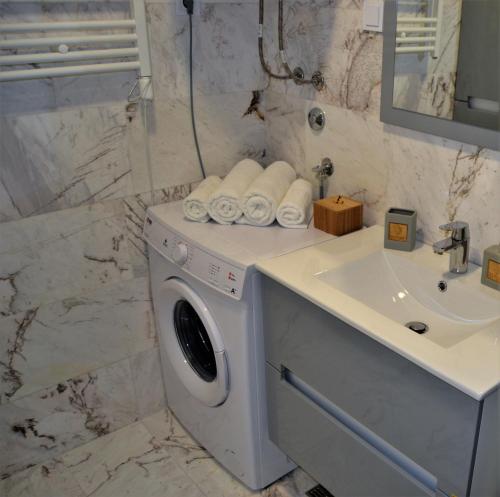 a bathroom with a washing machine and a sink at Yeshill Deluxe Apartment in Budva