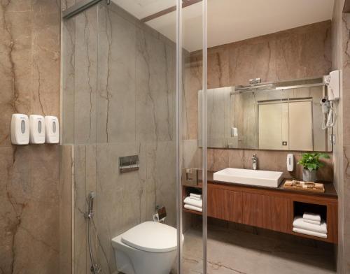 a bathroom with a toilet and a sink at CASTELO Inn in Nedumbassery