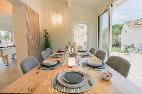 Villa Eden في Les Portes: غرفة طعام بها طاولة وكراسي خشبية