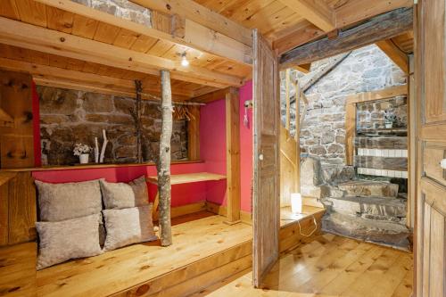 a living room with a stone wall and wooden floors at Cabañas con Encanto in San Roque de Ríomiera
