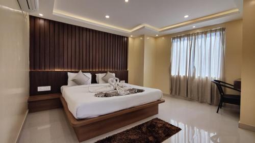 a bedroom with a large bed and a piano at Hotel Ridley International in Digha