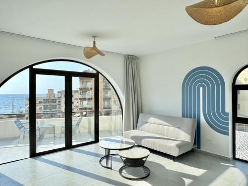 a living room with a couch and a table at Butterwave | 1BR Jacuzzi & Terrace in Kfar Aabida in Fad‘ūs