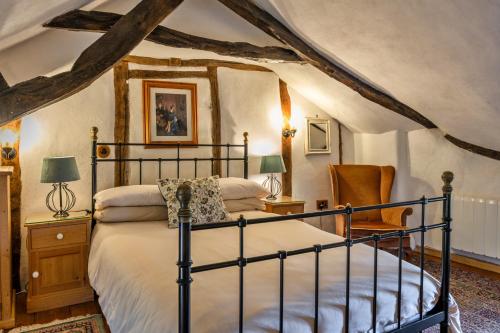 a bedroom with a bed and a chair at Finest Retreats - Syncocks Farm Cottage in Petrockstow