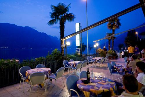 a restaurant with tables and chairs and a view of the ocean at Hotel Astoria - 3stelle S in Malcesine