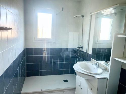 un bagno con lavandino e doccia di Rodger villa a Perpignano