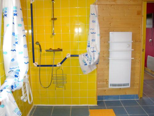 een badkamer met een douche en een gele tegelmuur bij Entre dunes et mer in Les Moitiers-dʼAllonne