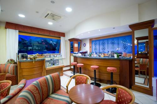 a bar with a couch and a table and chairs at Hotel Astoria - 3stelle S in Malcesine