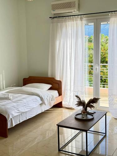 a bedroom with a bed and a table in front of a window at Apartment Mitrou in Loutra Oraias Elenis