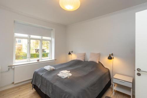 a bedroom with a large bed with two towels on it at Odinsvej Apartments - by Central Lyngby Apartments in Kongens Lyngby