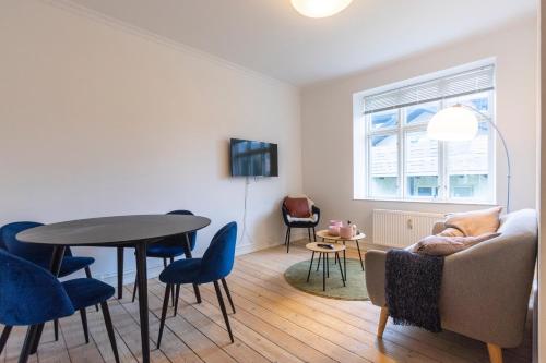 a living room with a couch and a table and chairs at Odinsvej Apartments - by Central Lyngby Apartments in Kongens Lyngby