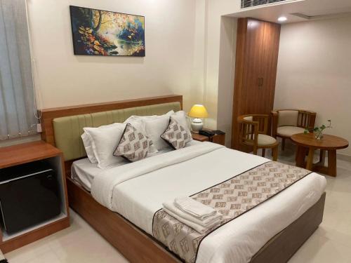 a bedroom with a bed and a table and chairs at Hotel octavia in Imphal
