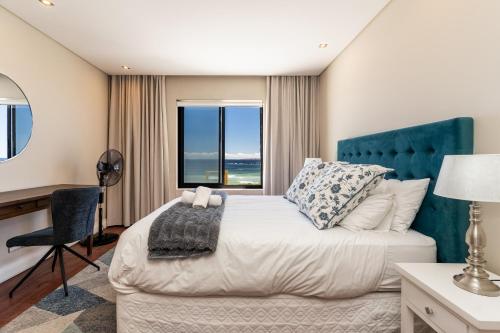 a bedroom with a bed and a desk and a window at 167 Eden on the Bay in Big Bay