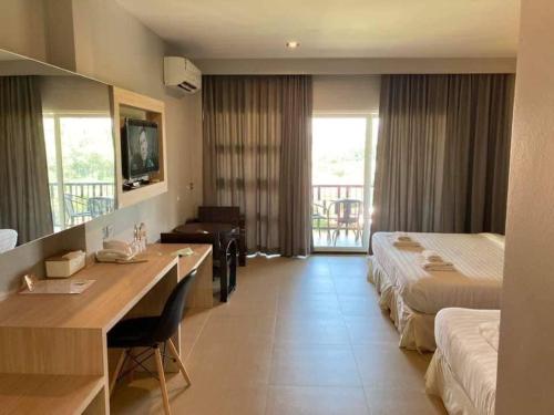 a hotel room with two beds and a desk at Pupha&Sila Home Resort in Betong