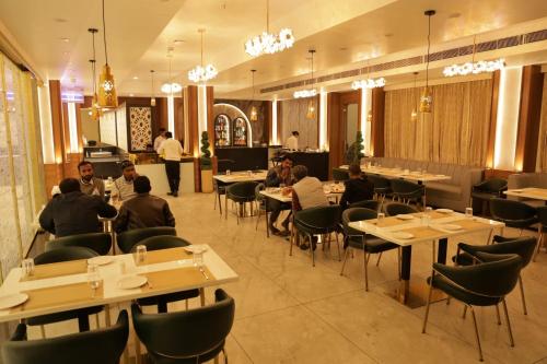 a group of people sitting at tables in a restaurant at Hotel Pritika Inn in Samastīpur