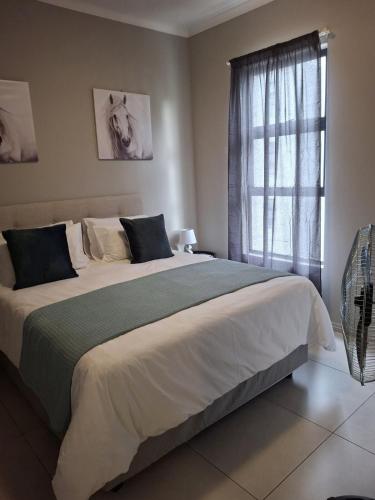 a bedroom with a large bed with a window at Oak and Olive Retreat Midrand in Midrand