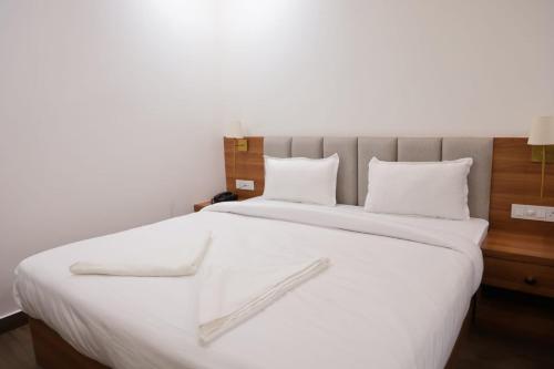 a large white bed with white sheets and pillows at Hotel Pritika Inn in Samastīpur