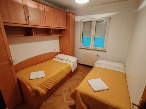 a small room with two beds and a window at Apartamentos Quien Anda Ahí Ribadeo in Ribadeo