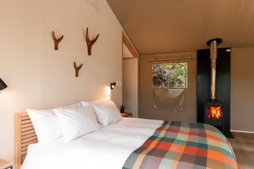 a bedroom with a bed with a fireplace in it at AfriCamps at Gowan Valley in Balgowan