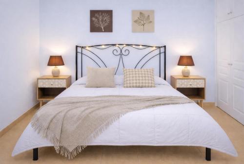 a bedroom with a large white bed with two lamps at Navigo house Vrachati in Vrachati