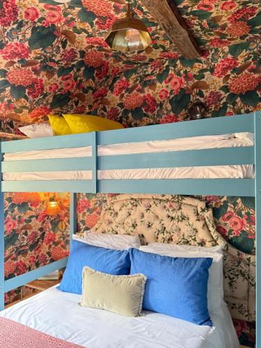 a bedroom with a blue bed with flowers on the wall at NEW - Periwinkle Townhouse - 3-min walk from Bath Spa Station in Bath
