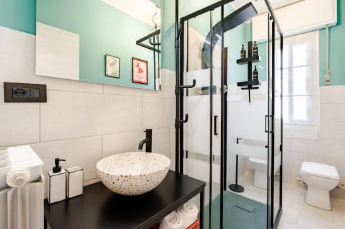 a bathroom with a sink and a glass shower at La casetta POP in Bordighera
