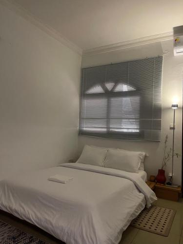 un letto bianco in una stanza con una finestra di Résidence chez-moi a Moosou