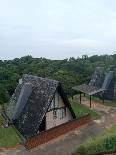 an image of a house with solar panels on the roof at Umzumbe Chalets Share Block ltd in Umzumbe