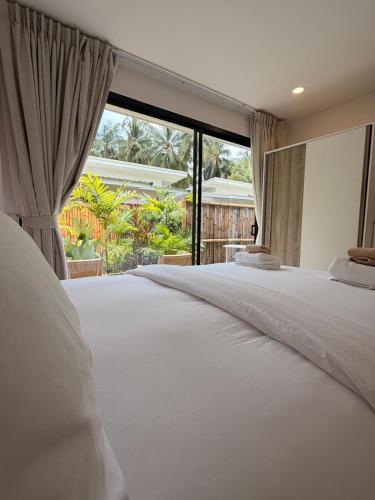 a bedroom with two beds and a large window at Srithanu Escape 1 in Srithanu