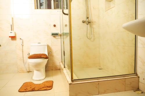 a bathroom with a shower and a toilet with a rug at Nestoria in Sagisa