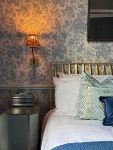 a bedroom with a bed with a lamp on a table at NEW - Periwinkle Townhouse - 3-min walk from Bath Spa Station in Bath