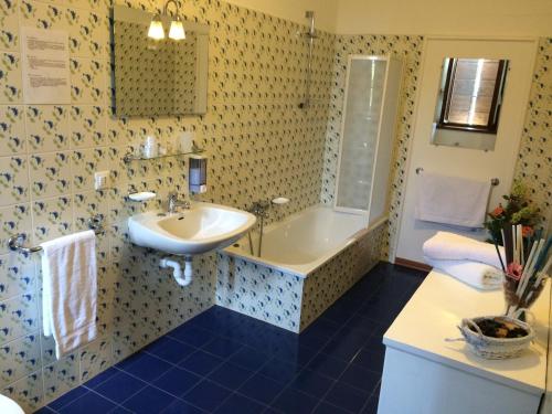 a bathroom with a sink and a bath tub at Casa Pellis in Fagagna