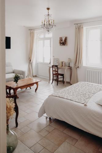 a bedroom with a bed and a table and chairs at La Marmittiere in Civray-de-Touraine