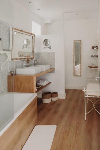 a white bathroom with a tub and a sink at La Marmittiere in Civray-de-Touraine