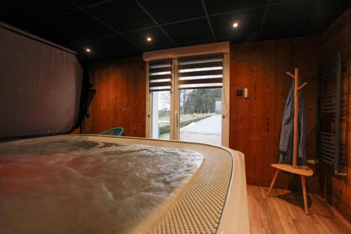 a room with a bed and a window and a chair at Gîte les Lilas Blancs 15mn Gérardmer in Champdray