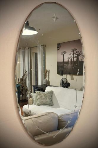 a living room with a white couch and a mirror at Fig Tree Rock 2-bed, 2-bath villa with garden and parking in Nelspruit