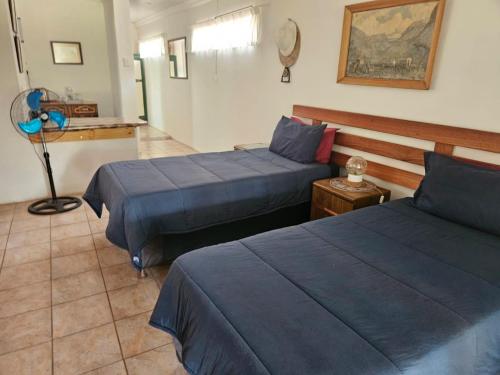 a hotel room with two beds and a fan at Carey 43 in Bothaville