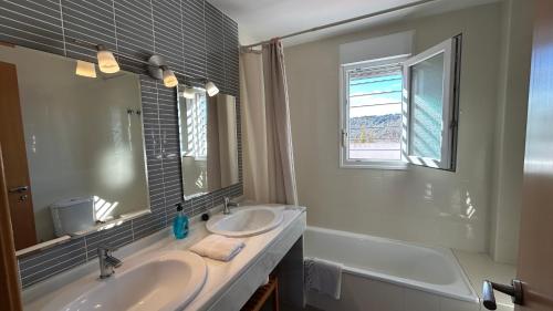 a bathroom with two sinks and a large mirror at Casa Rural Nacimiento del Hueznar - Tomillo 17 in San Nicolás del Puerto