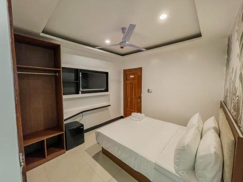 a bedroom with a bed and a ceiling fan at The Town - By Namal in El Nido
