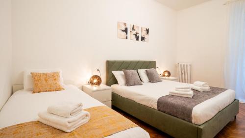 a bedroom with two beds with towels on them at Ramazzini District – Elegant Flat x8 in Milan